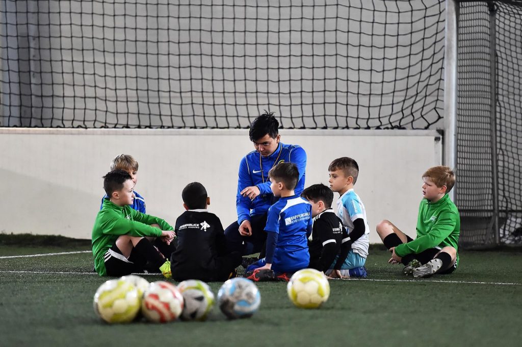 Trainer mit Fussballschülern im GEspräch