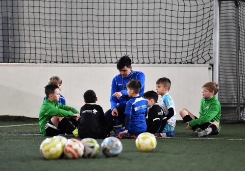 Trainer mit Fussballschülern im GEspräch